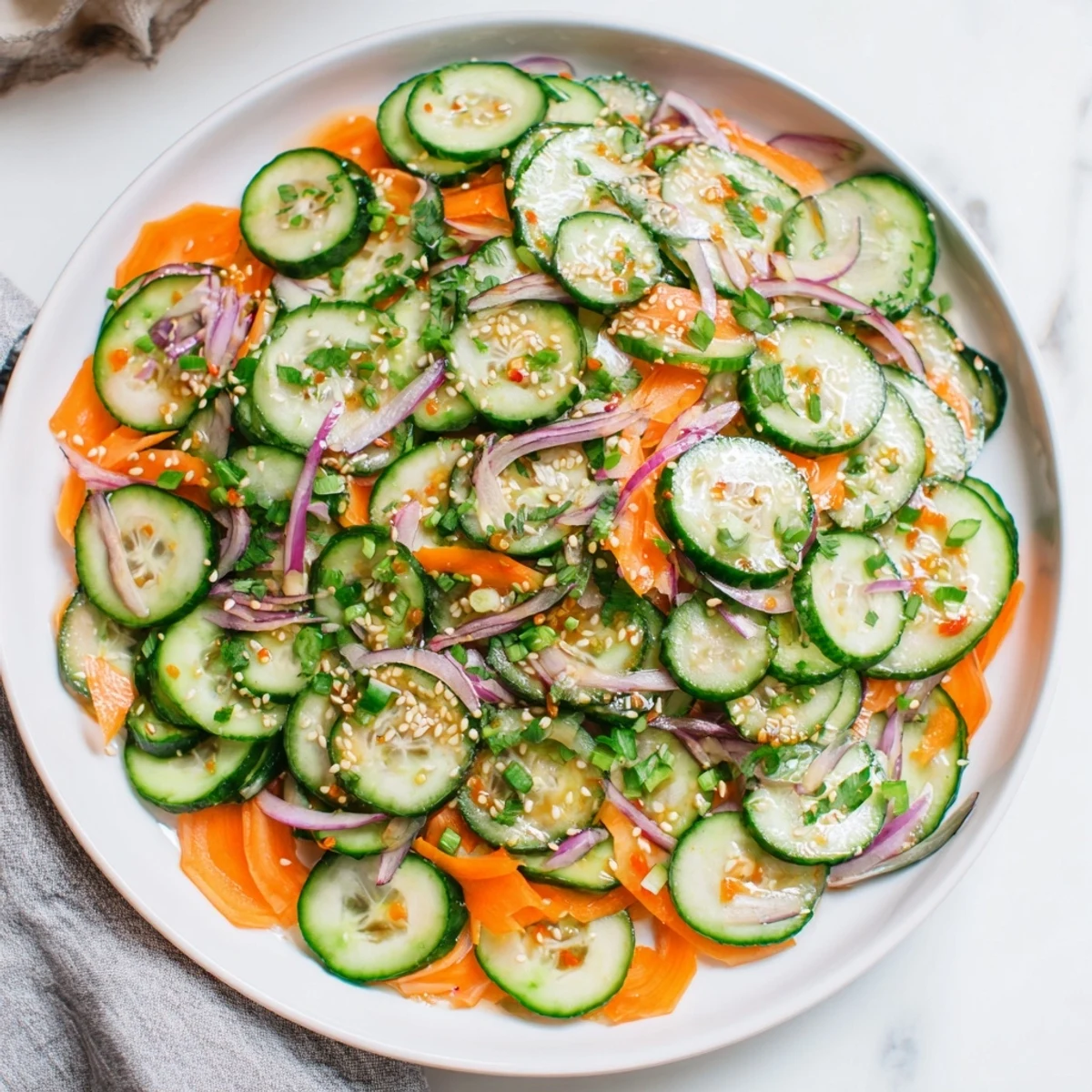 Refreshing cucumber salad remix garnished with toasted sesame seeds and fresh cilantro.  