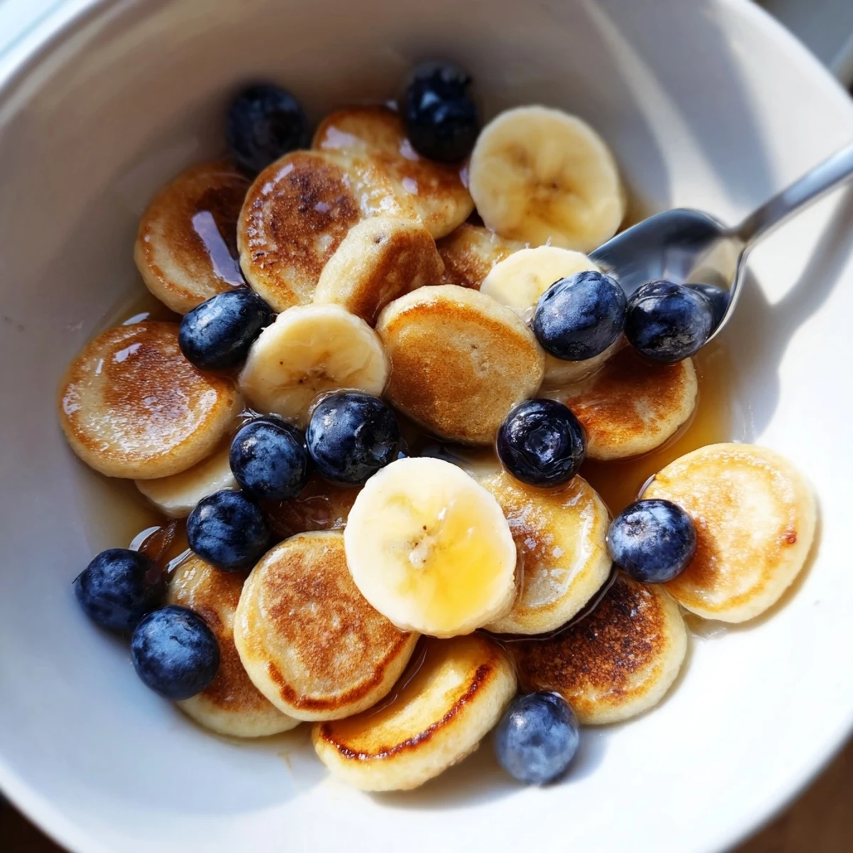 A colorful array of Mini Pancake Cereal drizzled with syrup, perfect for breakfast lovers.  