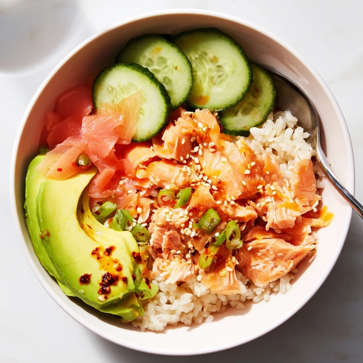 Delicious leftover salmon and rice bowl topped with fresh avocado and cucumber.  