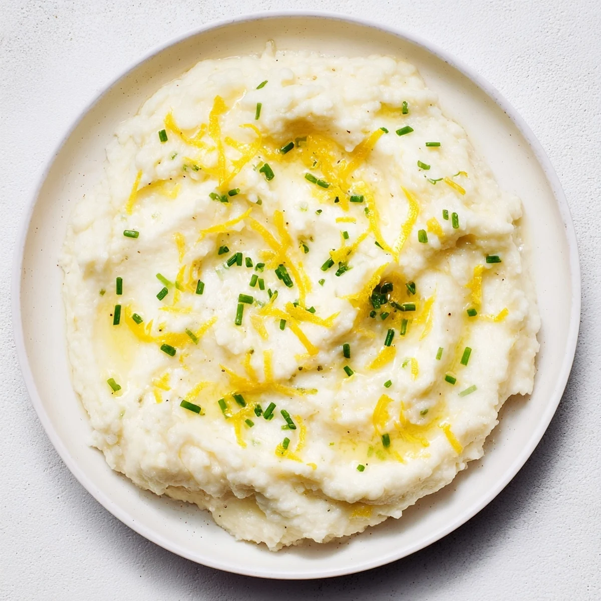 Fluffy cauliflower mash recipe, featuring roasted garlic and bright lemon zest, ready to enjoy.