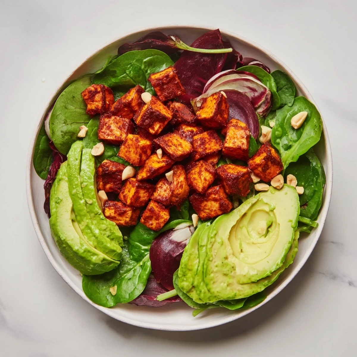 Imagine the layers: roasted sweet potatoes form the base of this vibrant Spiced Peanut Salad Bowl.