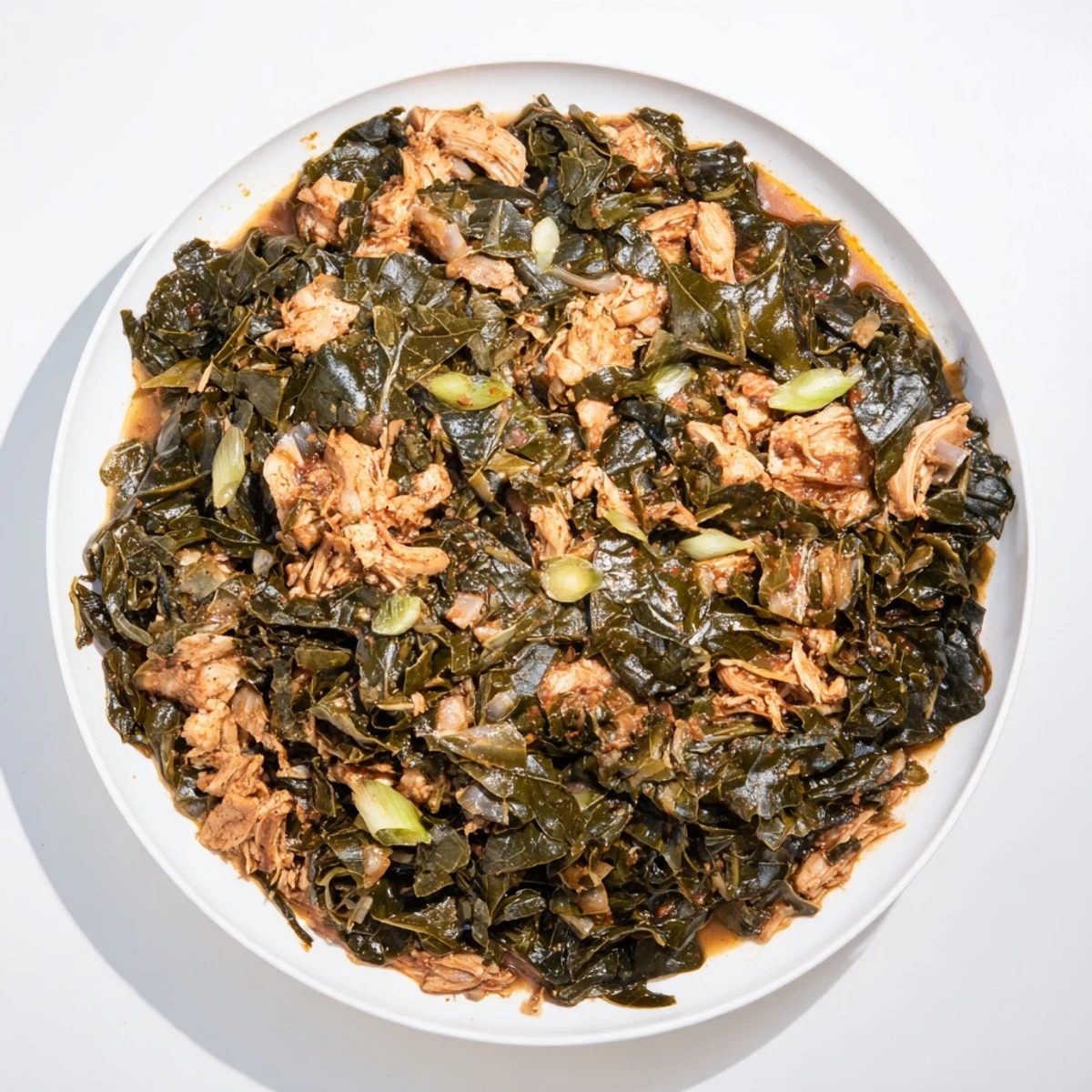 Tender Southern-style collard greens with smoky turkey, served steaming hot in a rustic bowl.