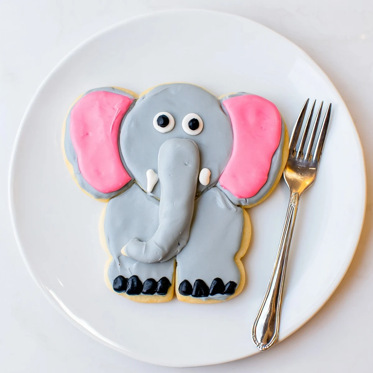 Giant, frosted Biscuits Amical Éléphant Géant cookies, featuring pink ears and edible candy eyes.