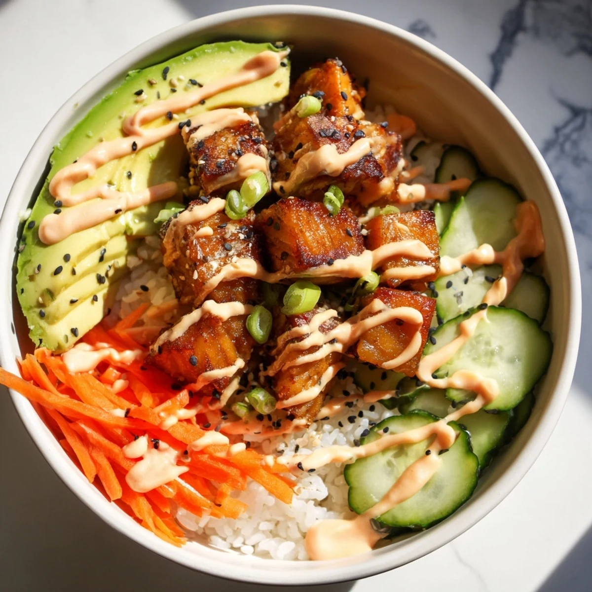 A delicious close-up of the flavorful salmon bites bowl with all its fresh toppings and sauce.