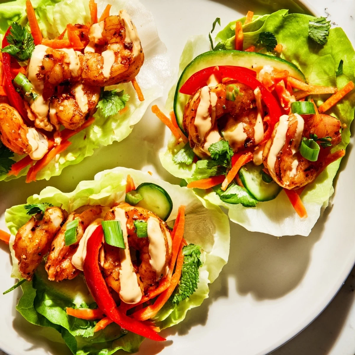 Vibrant shrimp lettuce cups filled with spicy shrimp, crisp vegetables, and a creamy sauce for a delicious, light meal.