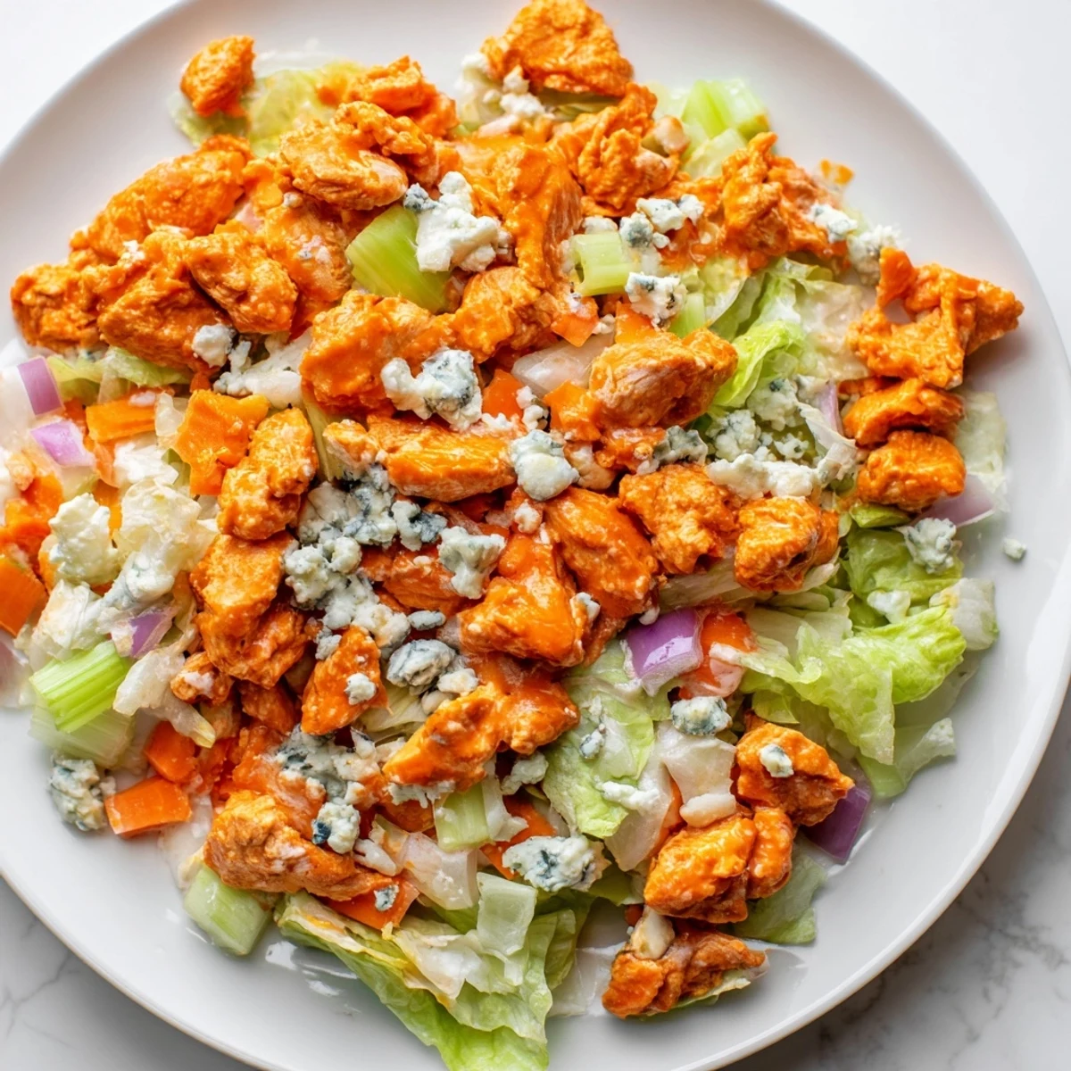 Tender, saucy buffalo chicken pieces over a hearty chopped salad, perfect for an easy, gluten-free weeknight dinner.