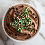 Festive Tree Brownie Dip, swirled and topped with holiday sprinkles, is perfect for dipping graham crackers.