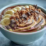 A nourishing Chocolate Peanut Butter Smoothie Bowl with creamy cocoa and peanut butter base, loaded with fresh banana slices and crunchy granola for a healthy breakfast.