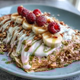 A close-up view shows a warm, thick pancake base made with oats and banana, piled high with tangy yogurt and vibrant berries.