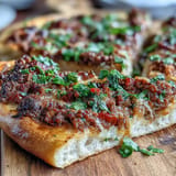 Golden Turkish Lahmacun Pizza with spiced ground lamb, ready to be garnished.