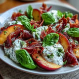 Peach burrata prosciutto salad with fresh basil, drizzled with balsamic glaze.