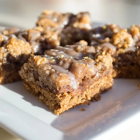 Golden-brown Lemon-Glazed Gingerbread Crumble Bars, drizzled with sweet lemon glaze, ready to serve.