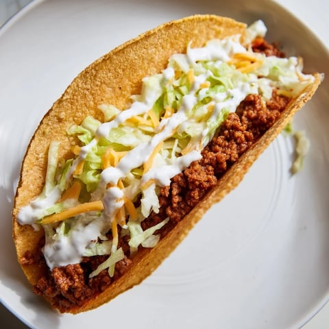 Steaming Cheesy Gordita Crunch tacos, a handheld delight with seasoned beef and melted cheese inside.