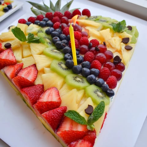 Vibrant Birthday Board: Cake Slice shaped fruit platter—strawberries, kiwi, and berries create a festive snack.