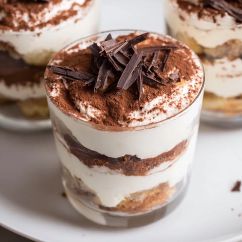 Creamy Countdown Tiramisu Shots layered with coffee-soaked ladyfingers, topped with cocoa, ready to serve.