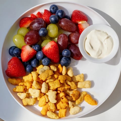 Brightly colored rainbow Goldfish crackers cascading over fresh berries, a playful snack.