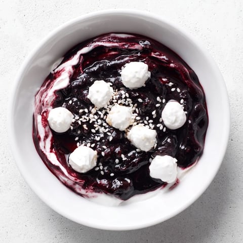 Vibrant Galaxy Spiral dessert: Berry jam swirls on creamy yogurt, sprinkled with sesame "stars".