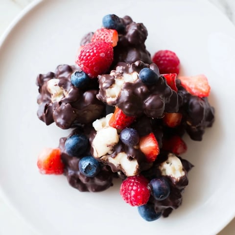 Chocolate Yogurt Clusters in a glossy dark chocolate coating, studded with vibrant berries, ready to devour.
