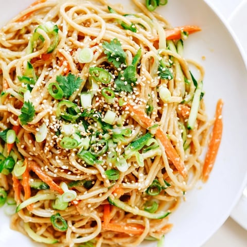 Cold sesame noodles, coated in a creamy sauce, are topped with crisp veggies for a light meal.