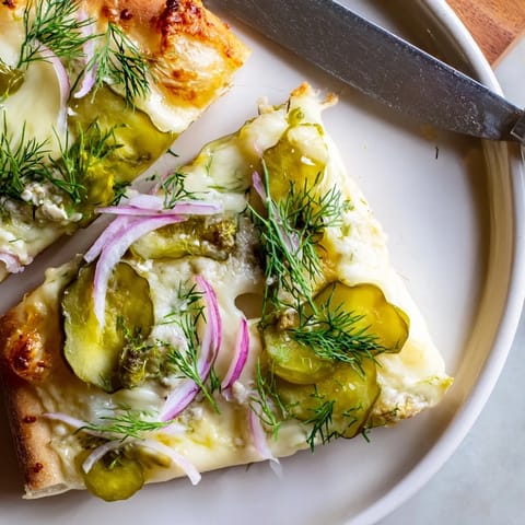 Delicious homemade Pickle Pizza, featuring melted cheese and zesty pickles on crust.  