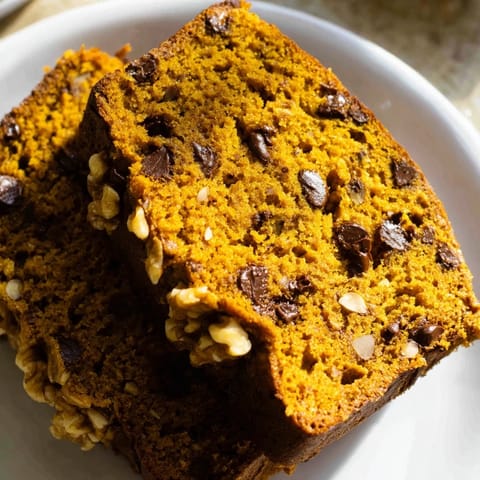 A close-up of a mug of pumpkin bread, steaming fresh from the microwave, perfect for a cozy snack.