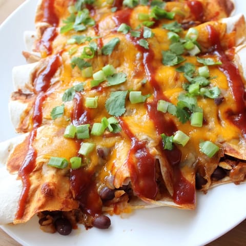 A close-up of cheesy, rolled Cheesy Bean Enchiladas ready to enjoy with family.