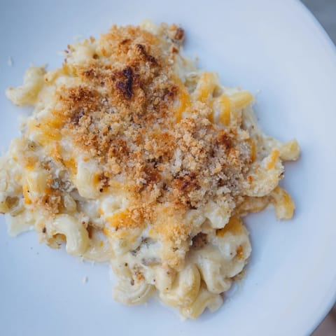 A close-up of creamy baked macaroni and cheese, boasting a crispy, golden-brown topping.