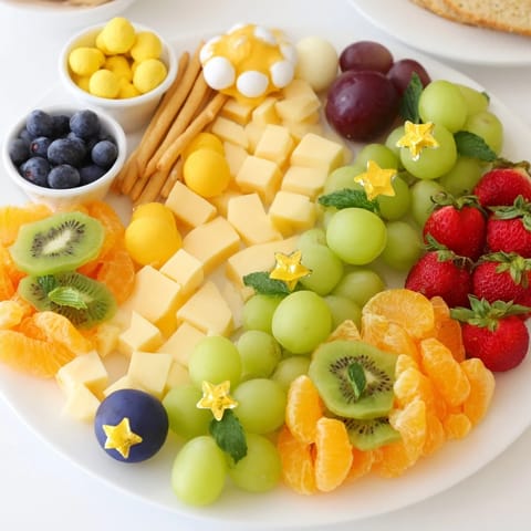 Vibrant Comet & Planet Grazing Tray: Cheeses, fruits, and crackers are delightfully arranged for a party.