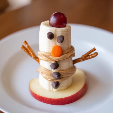 Homemade Banana Peanut Butter Snowmen, a fun holiday snack with peanut butter and berries.