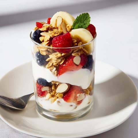 See fresh berries and banana slices elegantly layered in these Yogurt and Granola Parfait servings.