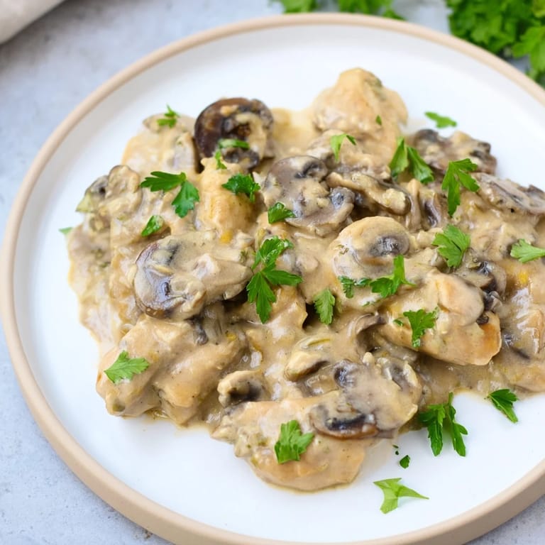 Golden-brown chicken pieces simmer in a creamy mushroom sauce for delicious Creamy Chicken Stroganoff.