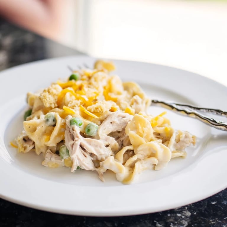 A comforting, flavorful photo of warm Creamy Tuna Noodle Casserole with a bubbly, golden crust.