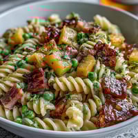 Hawaiian Pasta Salad with Ham, Pineapple, and Ranch in a creamy dressing, topped with colorful veggies. Perfect for summer picnics.  