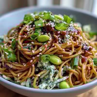 Sesame Ginger Noodle Bowl with crunchy cabbage and edamame, tossed in a zesty ginger dressing for a refreshing, protein-packed meal.